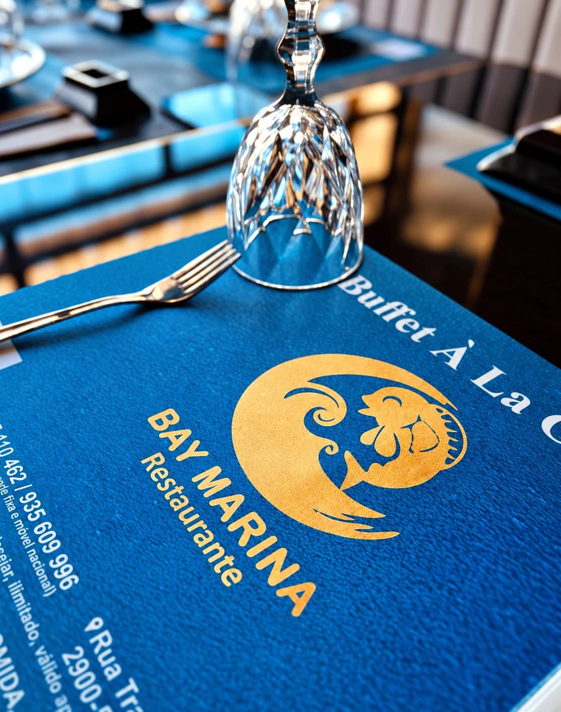 Pormenor da mesa com o menu e logótipo Bay Marina