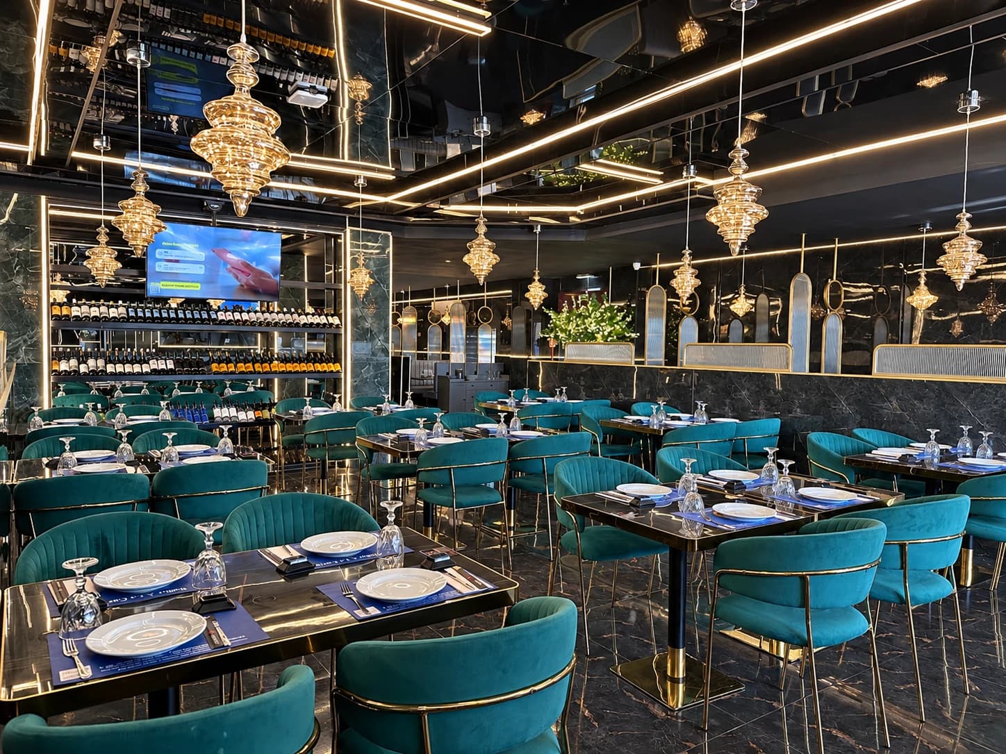 Sala com cadeiras verdes e iluminação dourada